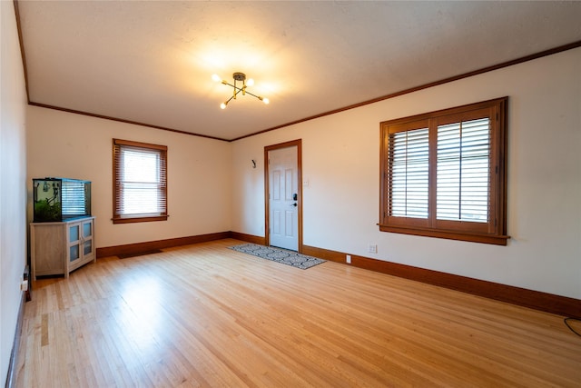 interior space with light wood-type flooring, baseboards, and ornamental molding