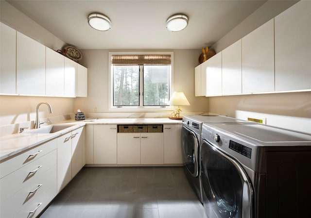 laundry area featuring cabinet space, washer and dryer, and a sink