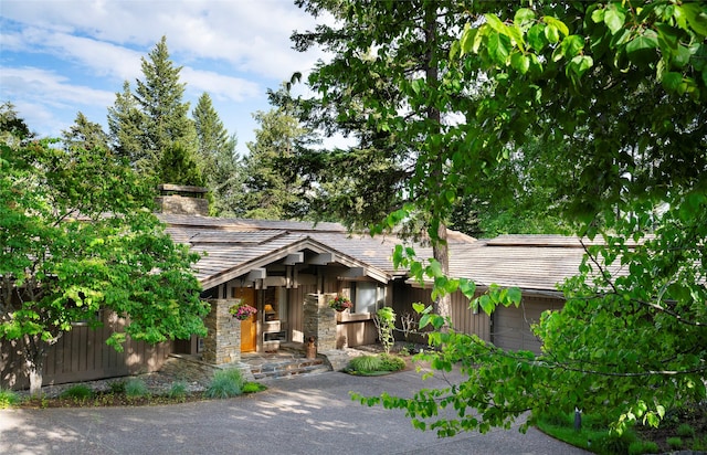 137 Eagle Bend Dr, Bigfork, MT 59911 - view of front of house featuring a chimney and stone siding