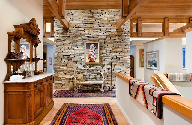 hall with beamed ceiling and light wood-style floors