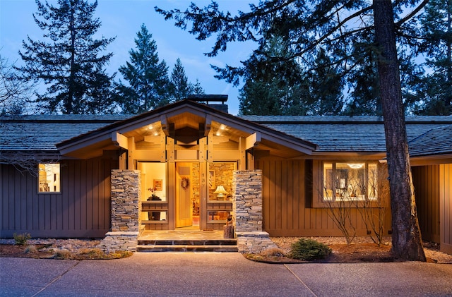 137 Eagle Bend Dr, Bigfork, MT 59911 - view of exterior entry with stone siding, roof with shingles, and covered porch