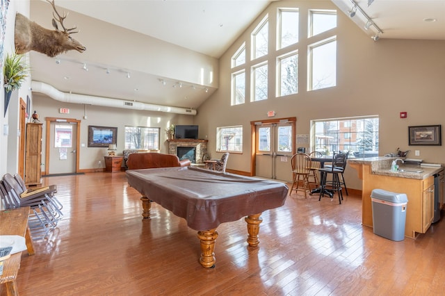 119 Oak St, Whitefish, MT 59937 - game room with track lighting, pool table, light wood-type flooring, a fireplace, and a towering ceiling