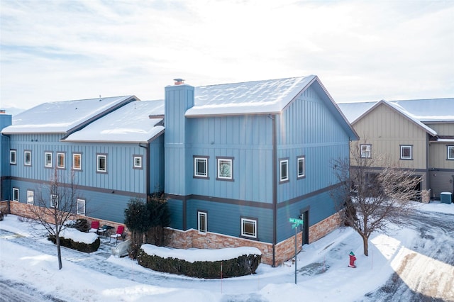 119 Oak St, Whitefish, MT 59937 - snow covered property with stone siding and a chimney
