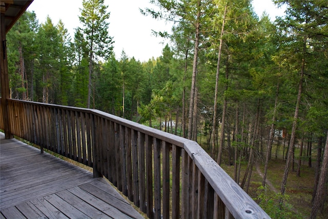 wooden terrace featuring a view of trees