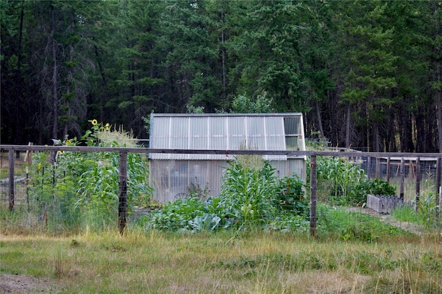 view of yard with a garden and a forest view