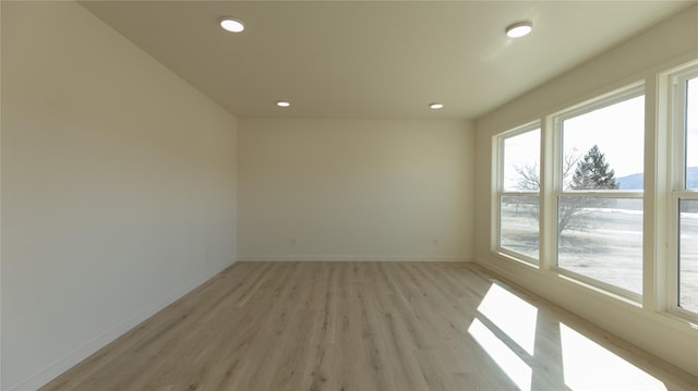 empty room featuring recessed lighting, light wood-style floors, and baseboards