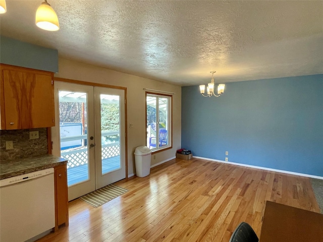 interior space featuring french doors, baseboards, light wood-type flooring, and an inviting chandelier