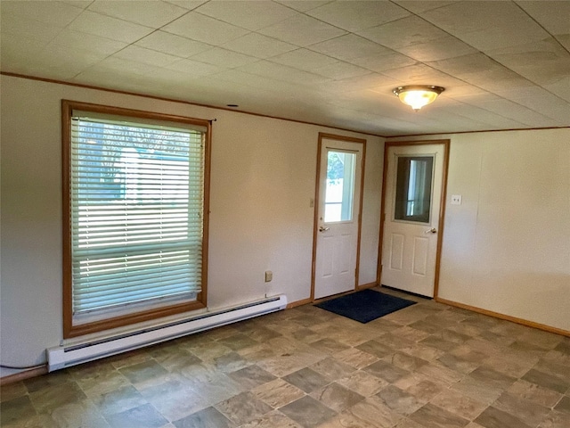 entryway featuring a baseboard heating unit, baseboards, and crown molding