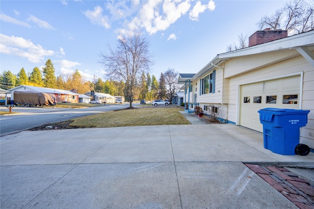1408 Nevada Ave, Libby, MT 59923 - view of property exterior featuring driveway, a chimney, an attached garage, and a residential view