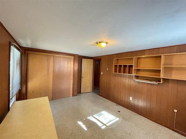 1408 Nevada Ave, Libby, MT 59923 - unfurnished bedroom featuring tile patterned floors, wooden walls, and a closet