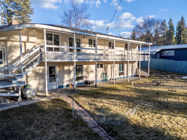 rear view of house with a patio area, a balcony, stairs, and fence