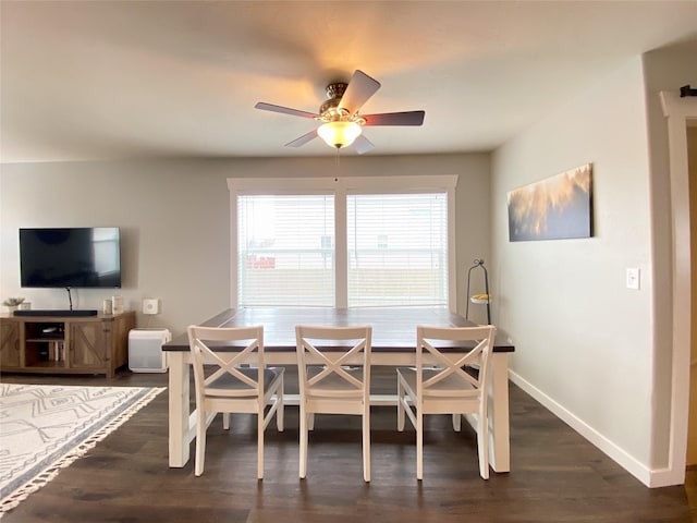 dining area with dark wood-style floors, ceiling fan, and baseboards