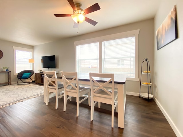 dining space featuring ceiling fan, baseboards, and dark wood finished floors