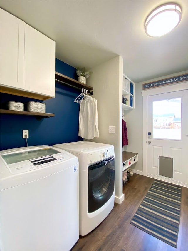 laundry area with dark wood-style floors, washing machine and dryer, cabinet space, and baseboards