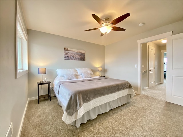 bedroom featuring light colored carpet, baseboards, and ceiling fan