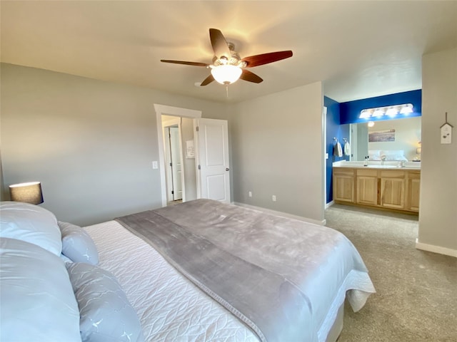 bedroom featuring baseboards, light carpet, a ceiling fan, and ensuite bathroom