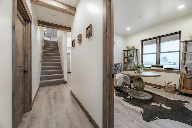 corridor featuring light wood finished floors, recessed lighting, stairs, and baseboards