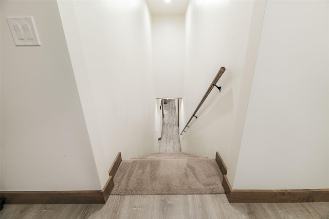 staircase with wood finished floors and baseboards