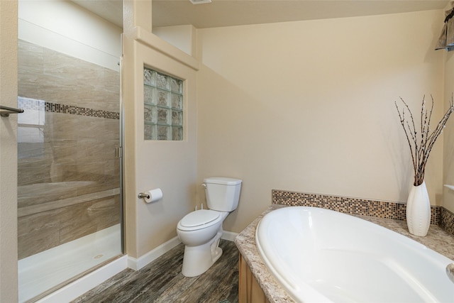 full bath featuring a garden tub, toilet, wood finished floors, a shower stall, and baseboards