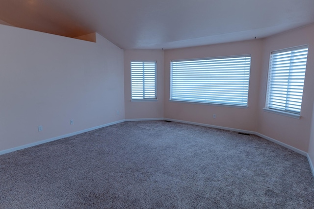 carpeted empty room with visible vents and baseboards