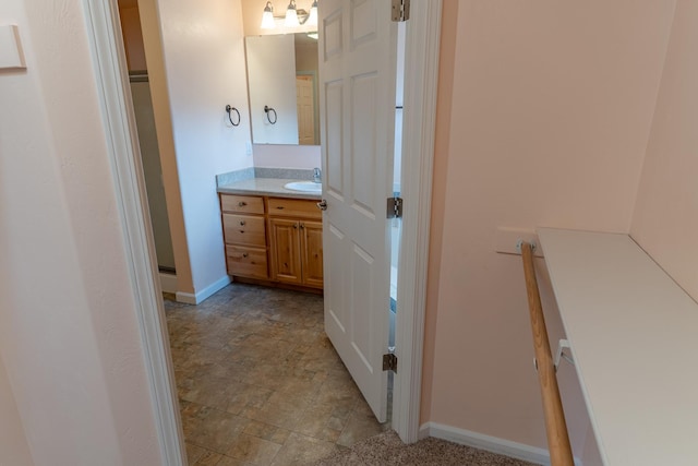 bathroom with vanity, stone finish floor, and baseboards