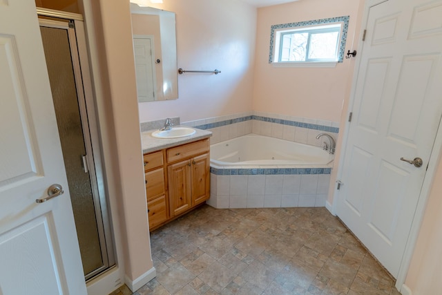 bathroom with stone finish flooring, vanity, a whirlpool tub, and a shower stall