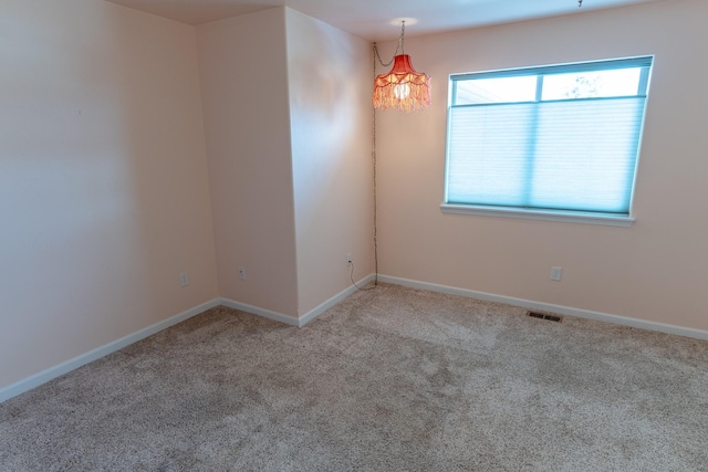 spare room with visible vents, carpet floors, and baseboards