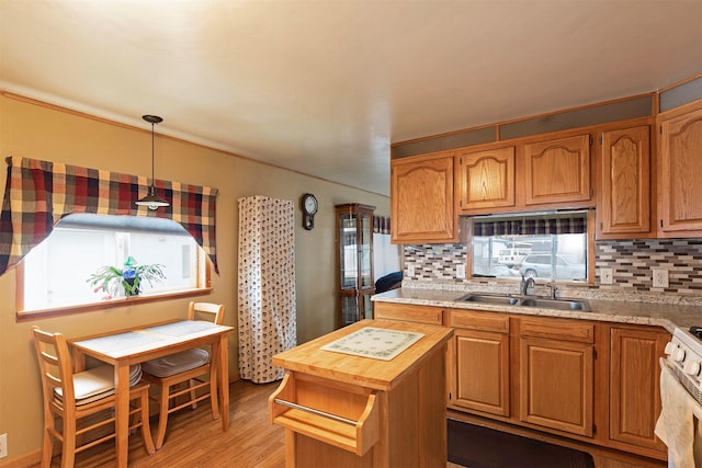 kitchen featuring tasteful backsplash, white range with gas cooktop, light wood finished floors, and a sink