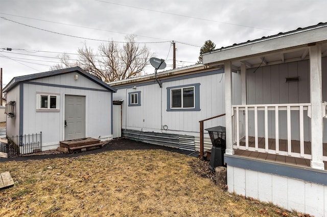 rear view of property with metal roof and an outdoor structure