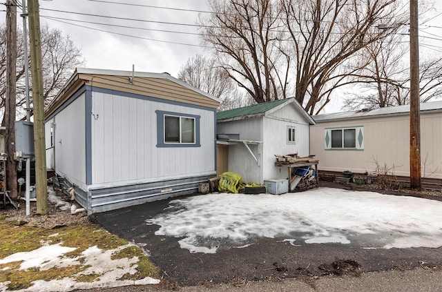 back of house featuring metal roof and an outdoor structure