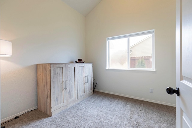 unfurnished bedroom featuring baseboards, carpet, and vaulted ceiling