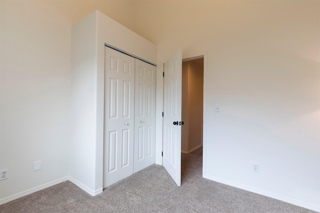 unfurnished bedroom with a closet, baseboards, and carpet flooring