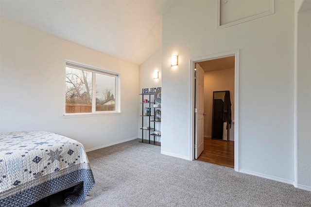 carpeted bedroom featuring lofted ceiling and baseboards