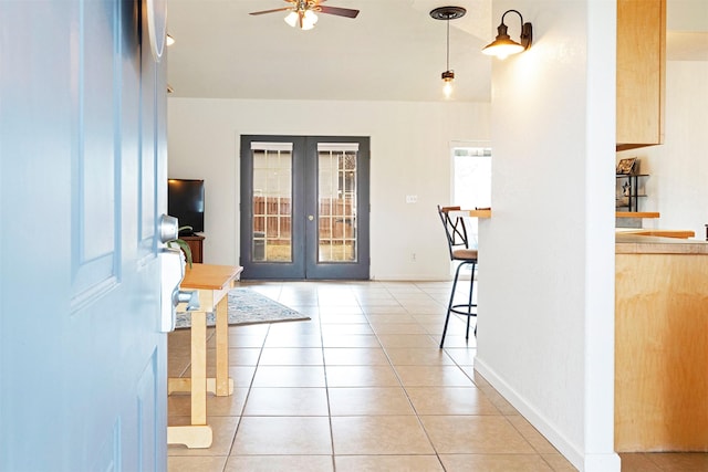 foyer entrance with ceiling fan, french doors, baseboards, and light tile patterned flooring