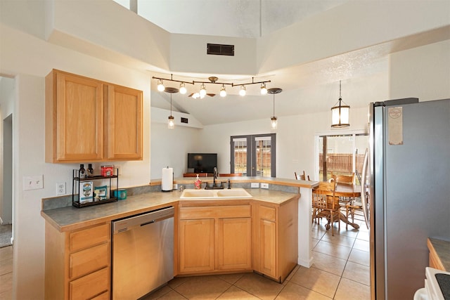 kitchen featuring light brown cabinets, visible vents, a peninsula, a sink, and appliances with stainless steel finishes