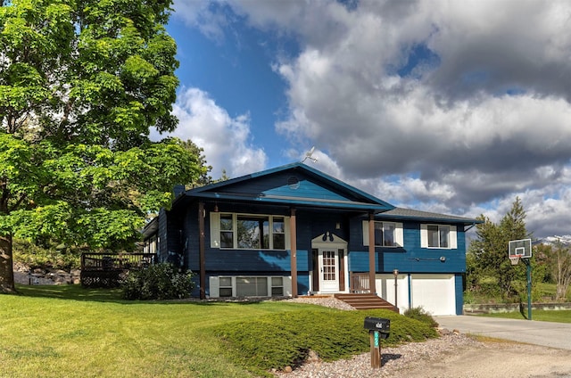 raised ranch featuring an attached garage, concrete driveway, and a front yard