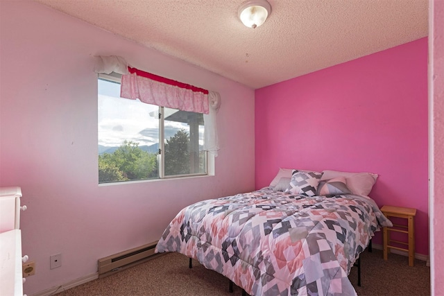 carpeted bedroom featuring baseboard heating and a textured ceiling