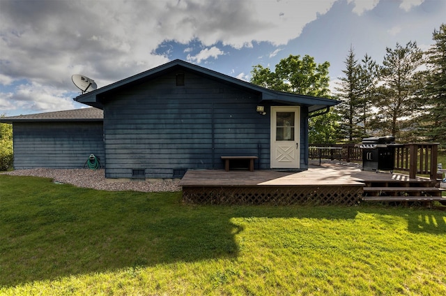 rear view of property featuring crawl space, a yard, and a deck