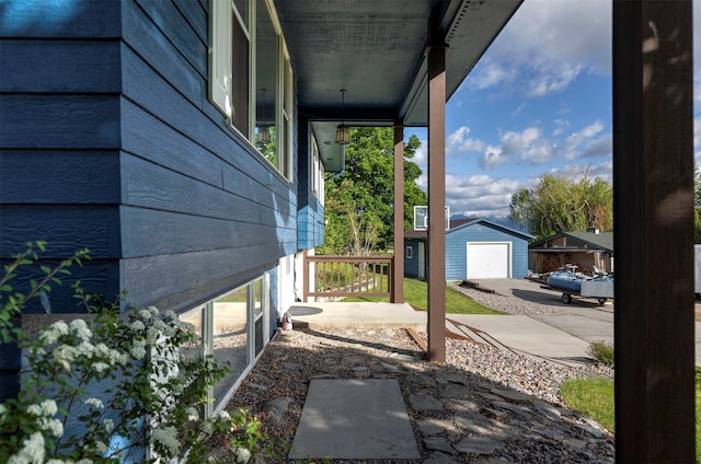 view of patio with a detached garage and an outdoor structure