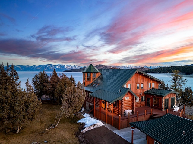 exterior space featuring log siding, metal roof, and a deck with mountain view