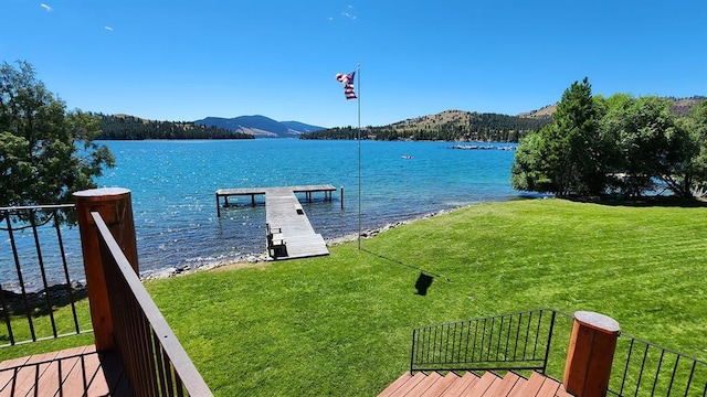 dock area with a yard and a water and mountain view