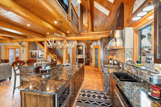 kitchen featuring tasteful backsplash, a sink, wood ceiling, and range with two ovens