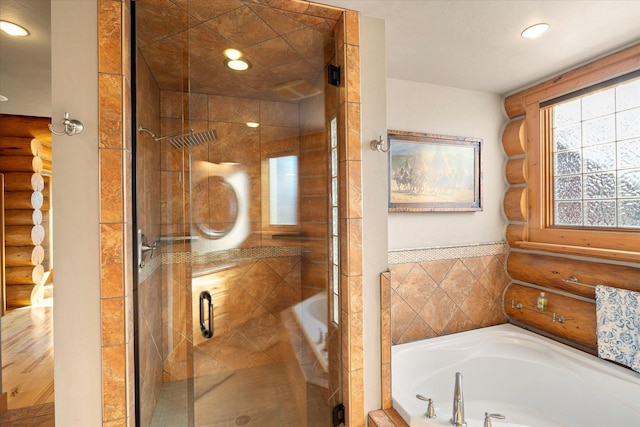 bathroom with a shower stall, a bath, recessed lighting, and log walls