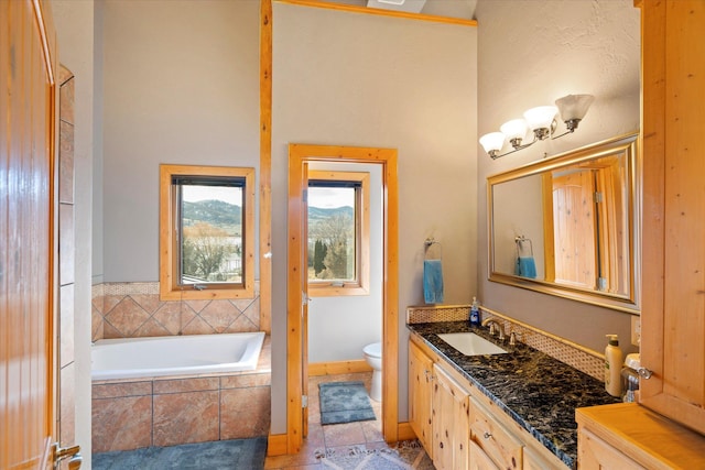 bathroom featuring vanity, baseboards, tile patterned flooring, a garden tub, and toilet