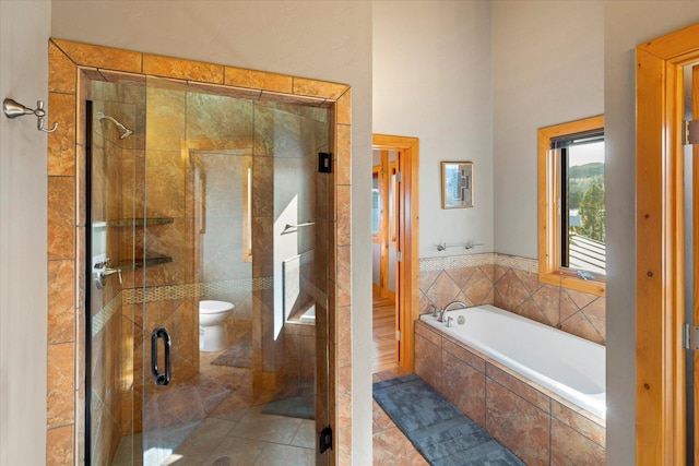 bathroom featuring a garden tub, toilet, a stall shower, and tile patterned floors