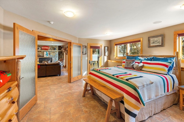 bedroom with baseboards, a fireplace, and stone finish floor