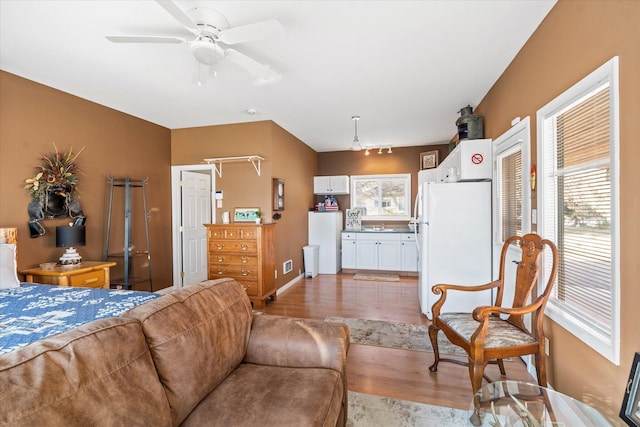 living area with light wood-type flooring and ceiling fan