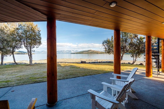 view of patio / terrace with a water and mountain view