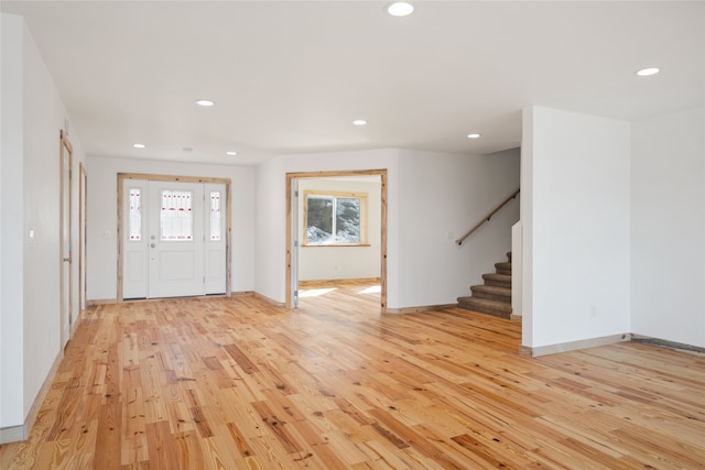 foyer entrance featuring recessed lighting, stairway, baseboards, and light wood-style floors