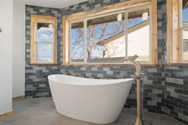 full bath with a soaking tub and tile walls